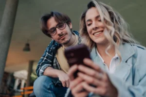 Students sharing social media content on smartphone outdoors